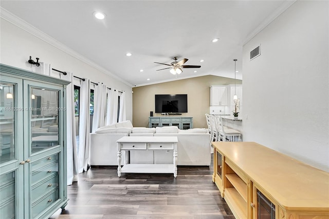 living room featuring crown molding, ceiling fan, dark hardwood / wood-style flooring, and vaulted ceiling