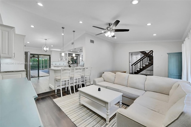 living room with dark hardwood / wood-style flooring, ornamental molding, and ceiling fan