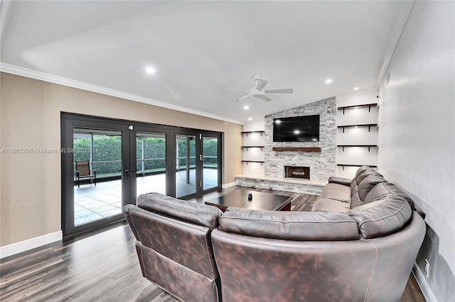 living room featuring a fireplace, lofted ceiling, hardwood / wood-style flooring, ornamental molding, and french doors