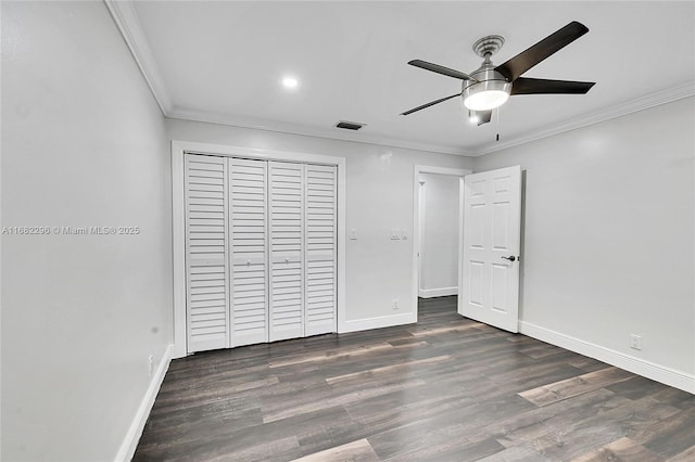 unfurnished bedroom featuring dark wood-type flooring, ceiling fan, ornamental molding, and a closet