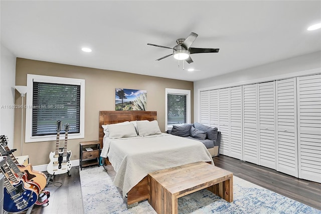 bedroom featuring ceiling fan, dark hardwood / wood-style floors, and multiple windows