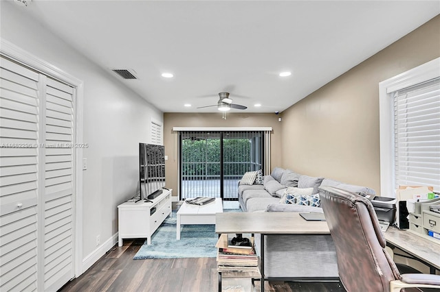 living room with dark wood-type flooring and ceiling fan