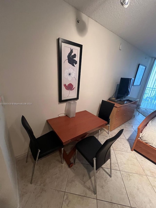 dining space featuring light tile patterned floors and a textured ceiling