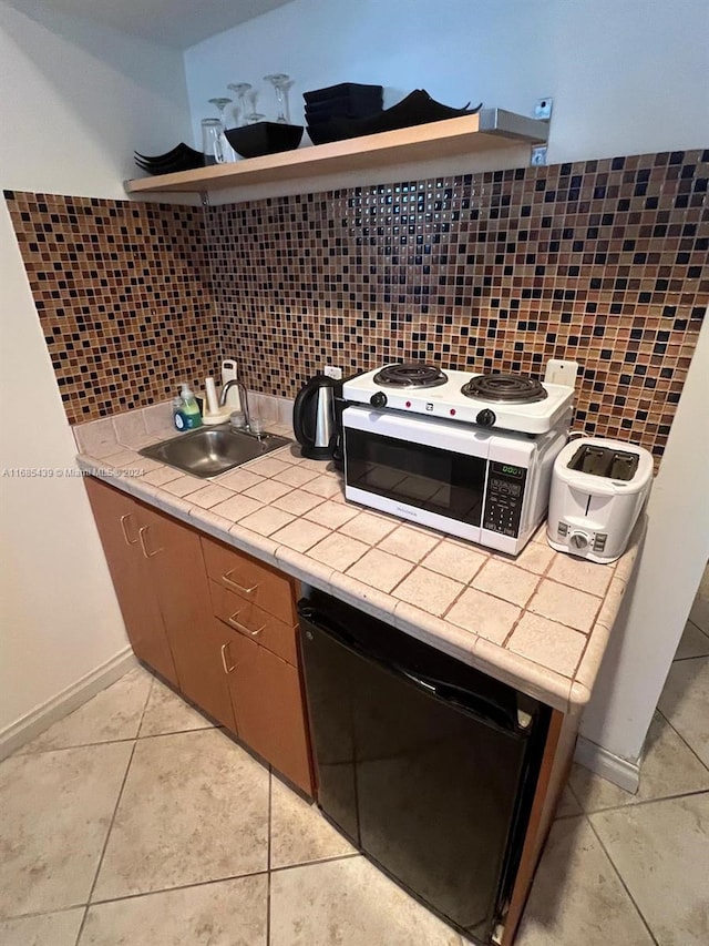 kitchen featuring backsplash, tile counters, and sink