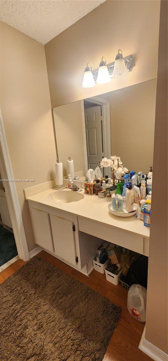 bathroom with vanity, a textured ceiling, and wood-type flooring