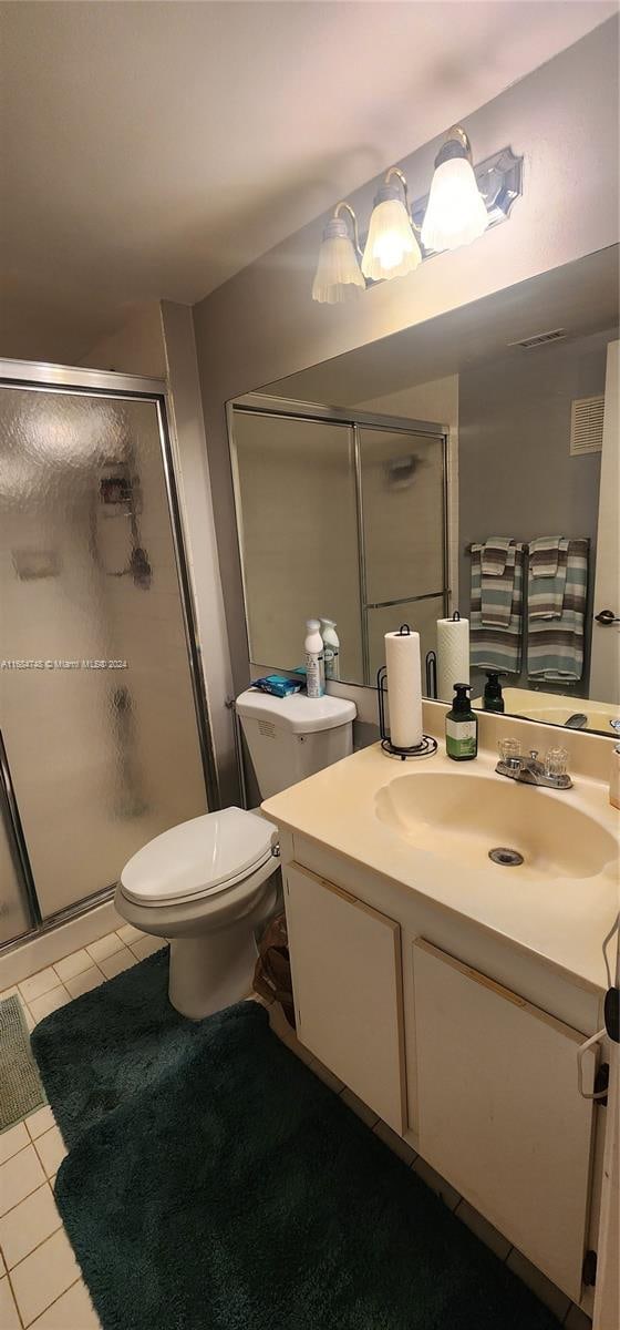 bathroom with vanity, an enclosed shower, toilet, and tile patterned flooring