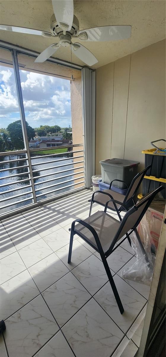 balcony with a water view and ceiling fan