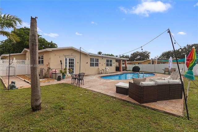 view of swimming pool with an outdoor living space, a patio, and a lawn