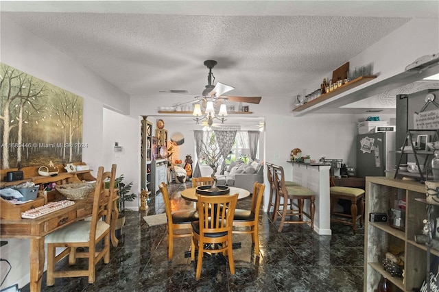 dining area featuring a textured ceiling and ceiling fan