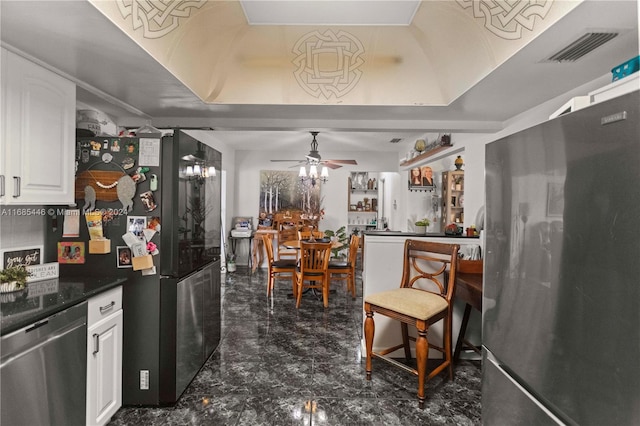 kitchen with white cabinets, stainless steel appliances, and ceiling fan with notable chandelier