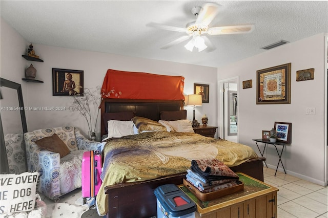 bedroom with ceiling fan, a textured ceiling, and light tile patterned floors