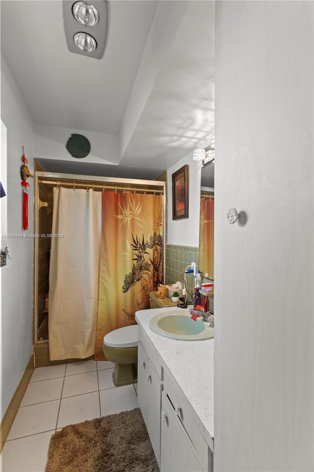 bathroom with decorative backsplash, toilet, tile patterned flooring, a shower with shower curtain, and vanity