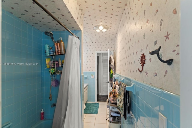 bathroom with vanity, shower / bath combo, tile patterned floors, and tile walls