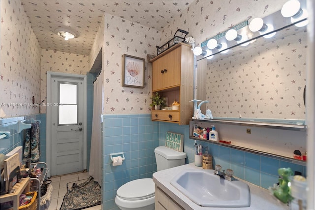 bathroom with toilet, tile patterned flooring, vanity, a shower with shower curtain, and tile walls