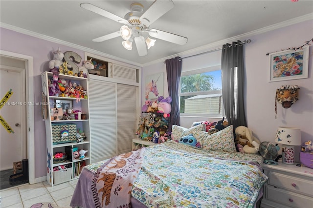 bedroom with crown molding, light tile patterned flooring, a closet, and ceiling fan