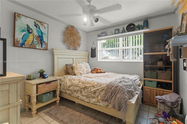 tiled bedroom with ceiling fan and ornamental molding