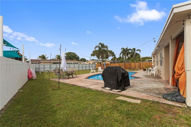 view of swimming pool featuring a patio area, a lawn, and grilling area