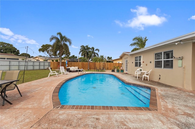 view of swimming pool with a yard and a patio