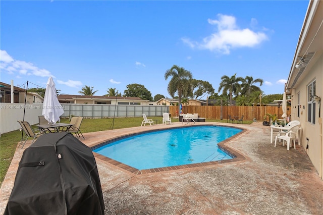 view of pool featuring a patio, a yard, and a grill