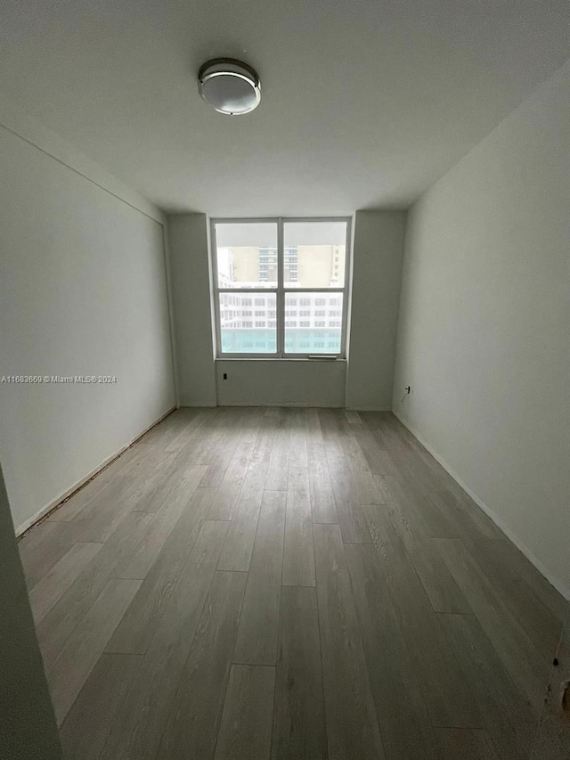 unfurnished room with hardwood / wood-style floors