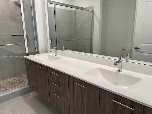 bathroom featuring vanity, a shower with shower door, toilet, and tile patterned floors