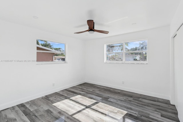 unfurnished room featuring dark hardwood / wood-style flooring, ceiling fan, and a wealth of natural light