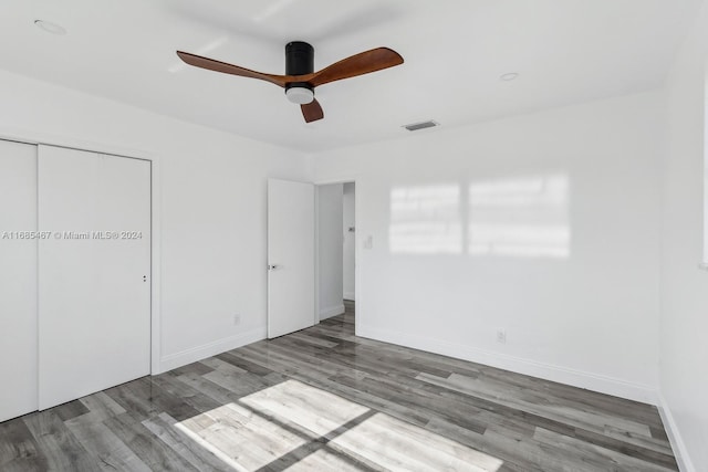 unfurnished bedroom with a closet, ceiling fan, and hardwood / wood-style floors