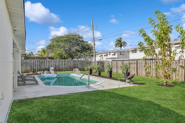 view of pool with a patio and a lawn