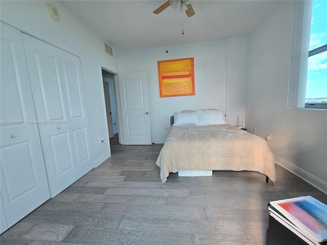 bedroom with a closet, hardwood / wood-style flooring, and ceiling fan