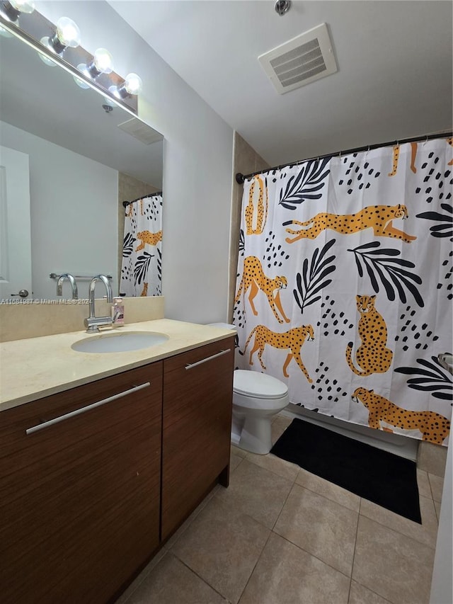 bathroom with toilet, vanity, tile patterned floors, and walk in shower