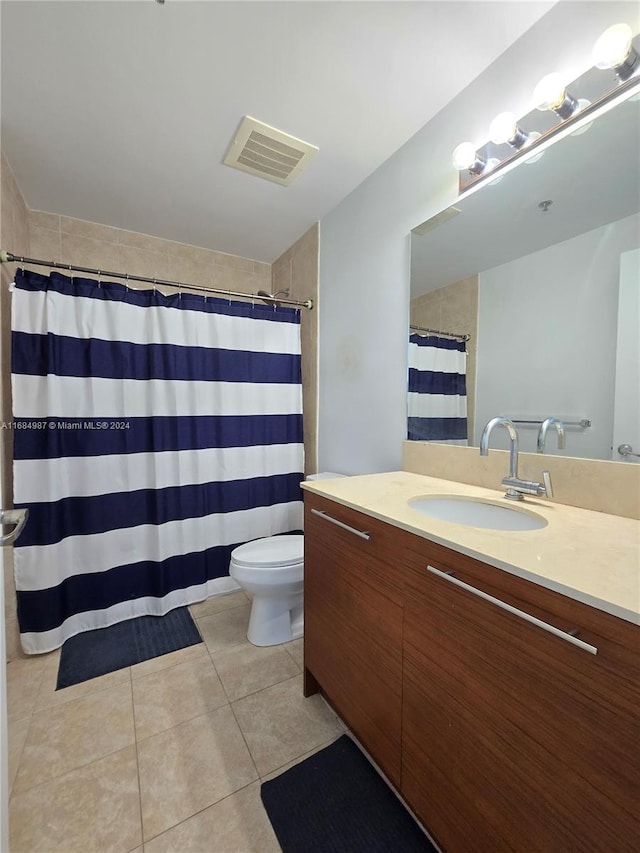 bathroom featuring vanity, tile patterned floors, and toilet