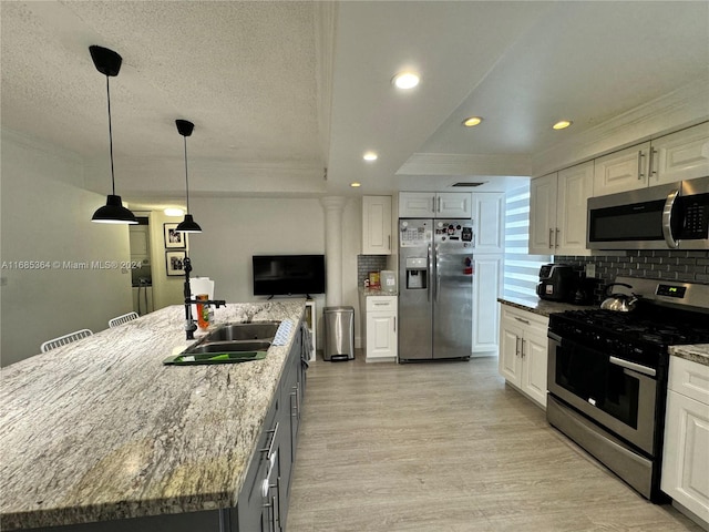 kitchen featuring a spacious island, appliances with stainless steel finishes, dark stone counters, and white cabinets