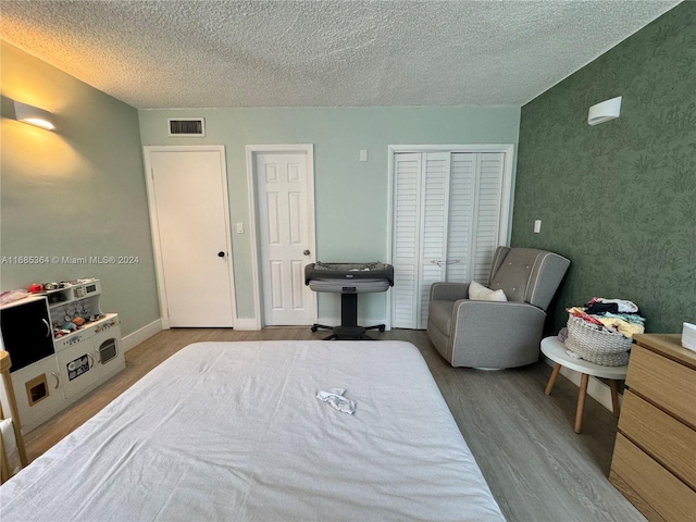 bedroom featuring a textured ceiling and hardwood / wood-style flooring