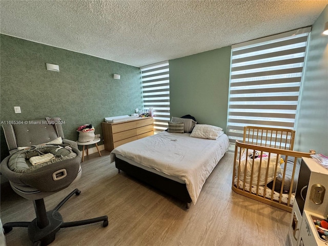 bedroom with a textured ceiling and hardwood / wood-style flooring