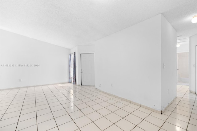 tiled spare room featuring a textured ceiling