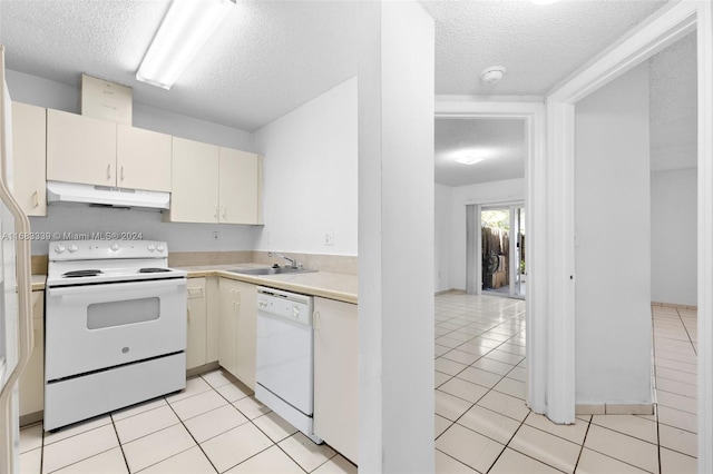 kitchen with white appliances, a textured ceiling, sink, and light tile patterned flooring