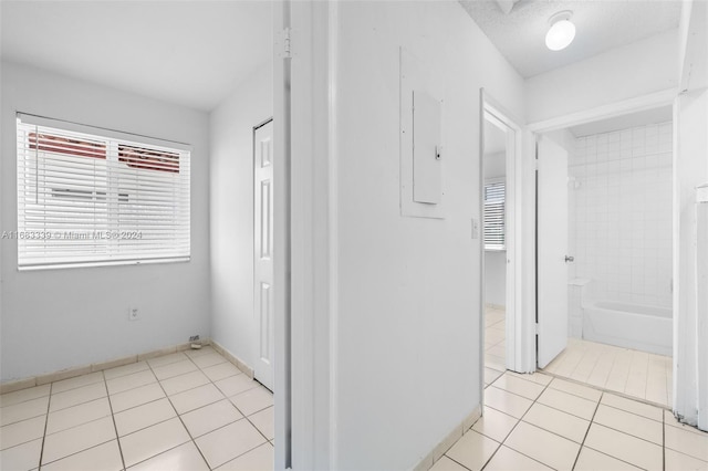 hallway with electric panel and light tile patterned floors