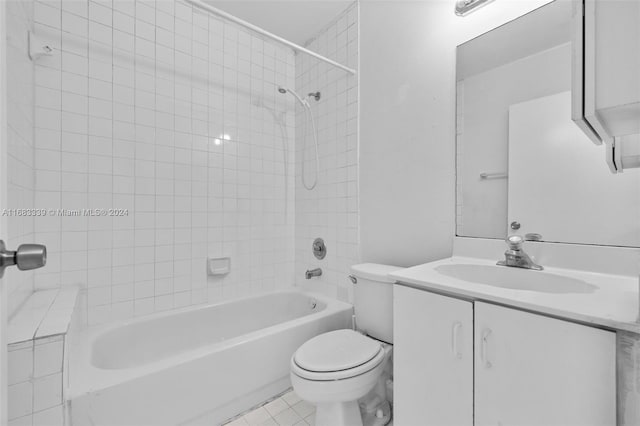 full bathroom featuring toilet, tiled shower / bath combo, vanity, and tile patterned flooring