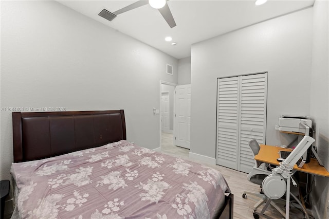 bedroom with baseboards, visible vents, ceiling fan, wood finished floors, and a closet