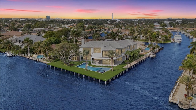 aerial view at dusk featuring a water view