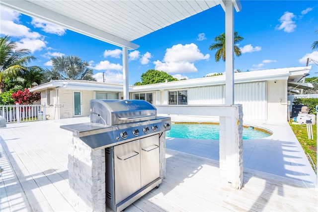 view of patio / terrace featuring a pool side deck, area for grilling, and a grill