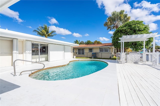 view of swimming pool with a wooden deck and a pergola