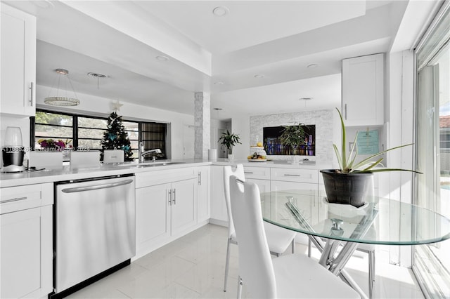 kitchen with sink, dishwasher, decorative columns, kitchen peninsula, and white cabinets