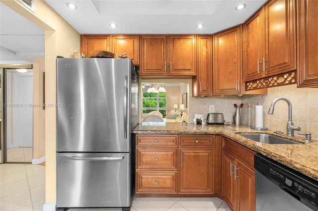 kitchen featuring sink, decorative backsplash, appliances with stainless steel finishes, light tile patterned flooring, and light stone counters