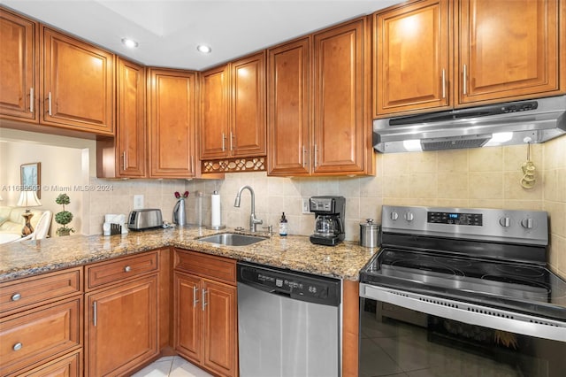 kitchen featuring light stone countertops, sink, stainless steel appliances, decorative backsplash, and light tile patterned flooring