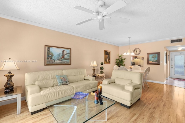 living room featuring crown molding, light hardwood / wood-style flooring, ceiling fan with notable chandelier, and a textured ceiling