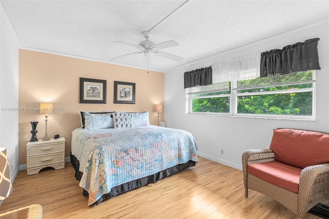 bedroom with ceiling fan, crown molding, wood-type flooring, and a textured ceiling