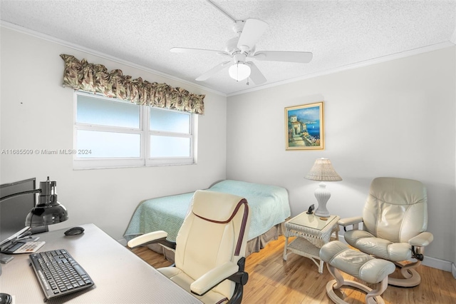 bedroom featuring a textured ceiling, hardwood / wood-style flooring, ceiling fan, and ornamental molding