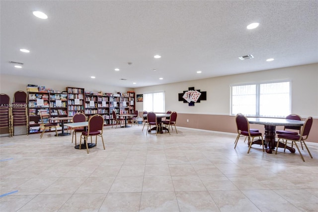 tiled dining room with a textured ceiling