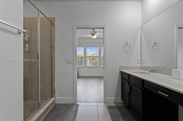 bathroom with ceiling fan, vanity, a shower with door, and tile patterned flooring